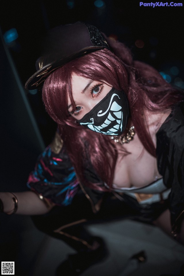 A woman with red hair wearing a mask and a hat.