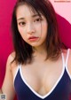 A woman in a blue and white bathing suit posing for a picture.