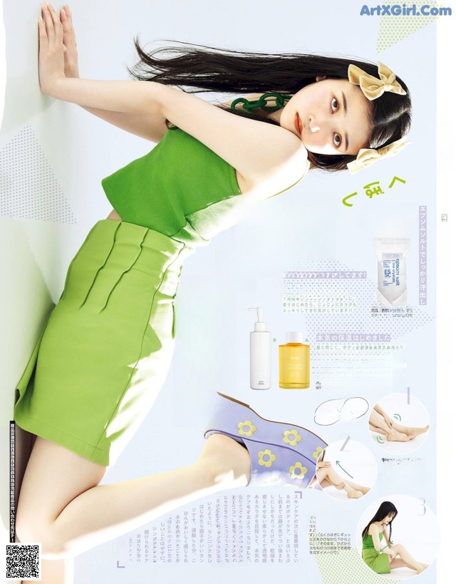 A woman in a green dress leaning against a wall.