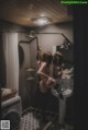 A woman standing in front of a mirror in a bathroom.