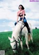 A woman riding on the back of a white horse.