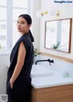 A woman standing in front of a sink in a bathroom.