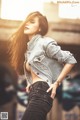 A woman in a denim jacket and jeans posing for a picture.