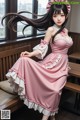 A woman in a pink dress sitting on a bench.